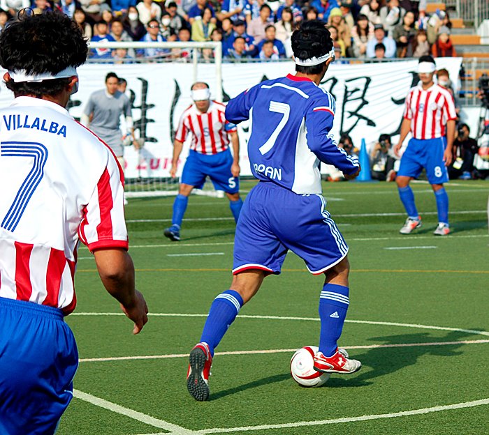 開幕戦で、ドリブルで攻め込む、日本の川村怜選手(中央)=2014年11月16日/国立代々木競技場フットサルコート