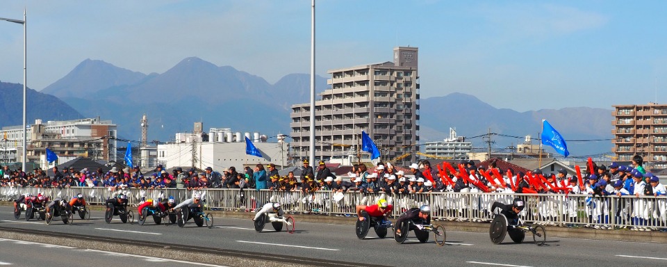 11月17日に晴天の大分市で開催された「大分国際車いすマラソン」で、弁天大橋上で先頭集団を応援する野球少年たち。今年39回目を迎えた伝統の大会。町をあげての大声援はすっかり風物詩に。