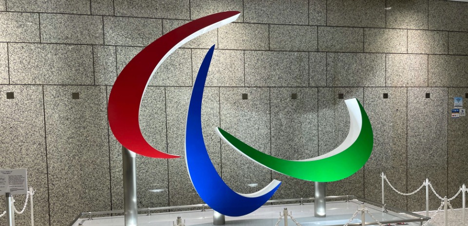 パラリンピックのシンボルマーク「スリーアギトス」。「アギト」とはラテン語で「私は動く」という意味で、3本の曲線で、躍動するアスリートの姿などを表現している。赤・青・緑は世界の国旗で最も使われている３色から選ばれたという。（撮影：東京都庁にて）