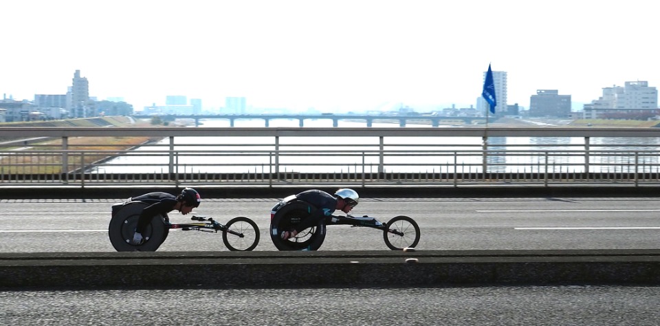 2021年11月21日、大分市で開催された「第40回大分国際車いすマラソン」で、競り合うスイスのマルセル・フグ選手（右）と鈴木朋樹選手
