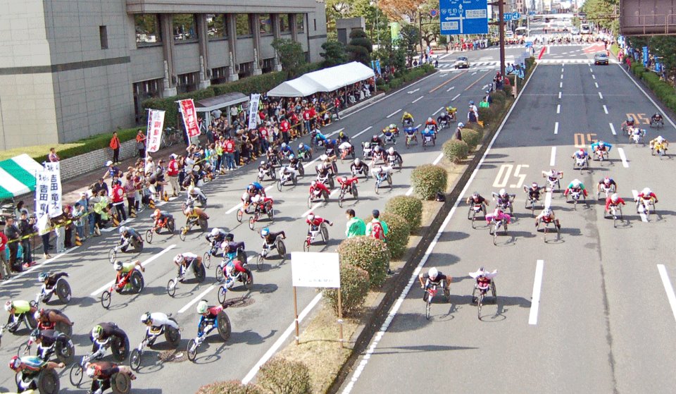 世界最古の車いすだけのマラソン大会「大分国際車いすマラソン」の2015年大会のスタート(11月8日)。向かって右側車線の先頭選手2人のうち、右側のランナーが土田和歌子選手(撮影:星野恭子)