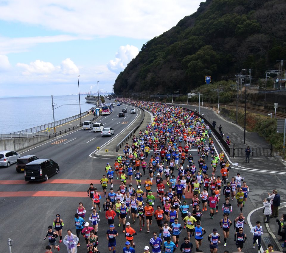 別府大分毎日マラソンのスタートから2km手前を疾走するランナーたち。ブラインドランナー19人(男子13人、女子6人)を含む、過去最多となる3402人が出走した。(2016年2月7日/大分県別府市=撮影:星野恭子)