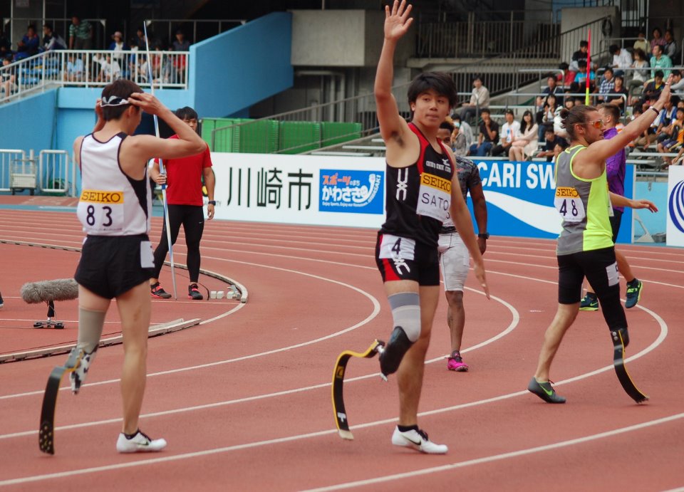 100mフィニッシュ後、歓声に応える佐藤選手（中）とウォレス選手（右）。83番は春田選手＝同